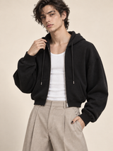AI-generated model Jules wearing the black Everyday Zip Hoodie unzipped over a white tank with stone trousers