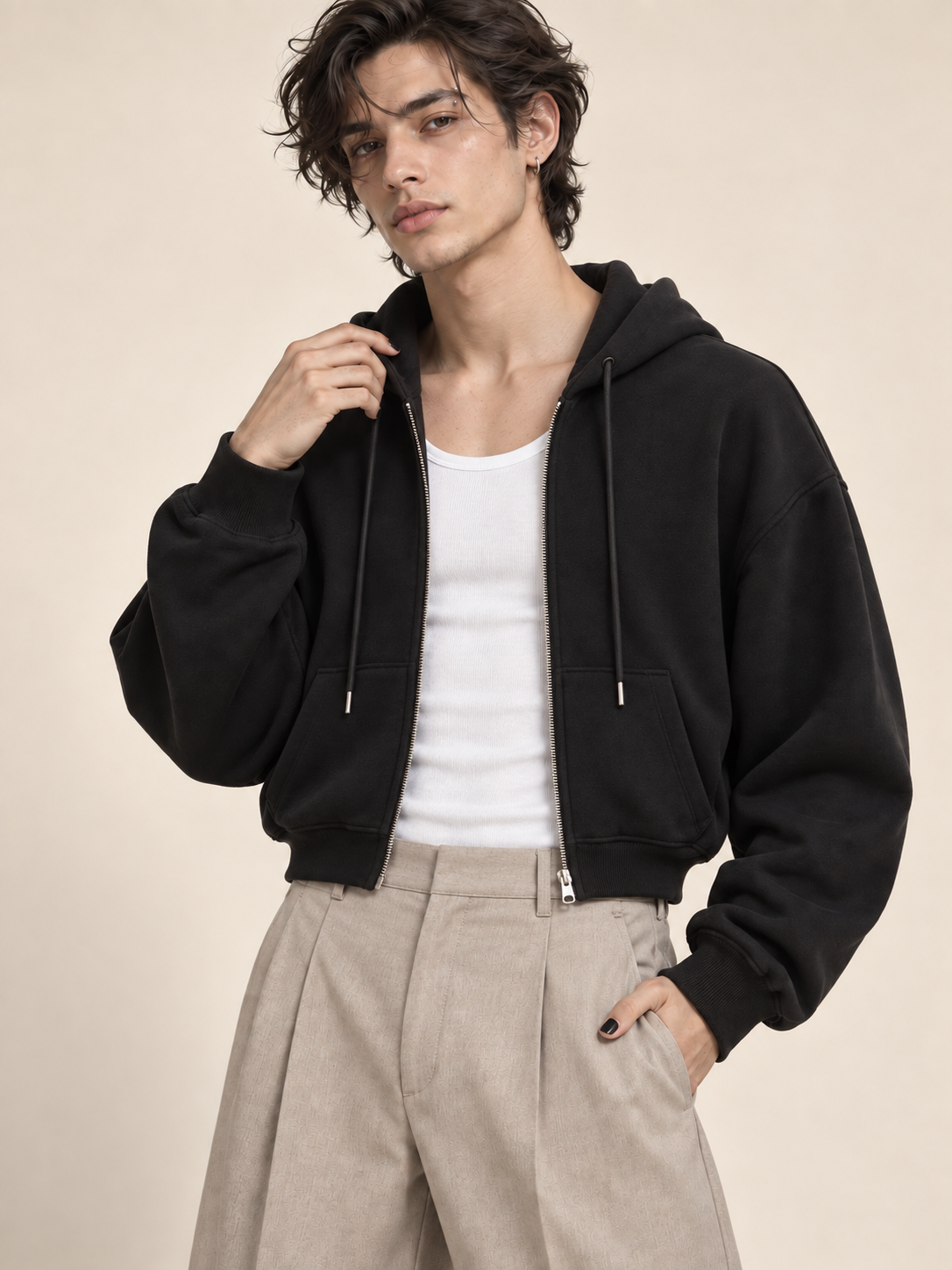 AI-generated model Jules wearing the black Everyday Zip Hoodie unzipped over a white tank with stone trousers