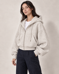 AI-generated model Maya wearing the light gray Everyday Zip Hoodie with navy trousers