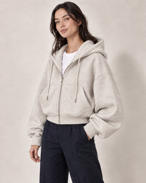 AI-generated model Maya wearing the light gray Everyday Zip Hoodie with navy trousers
