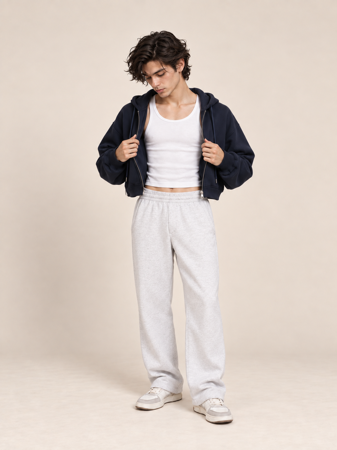 AI-generated model Jules holding the cropped navy Everyday Zip Hoodie open over a white tank and heather-white sweatpants